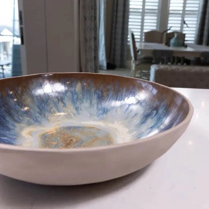 A glazed Berlin Gray bowl with blue and cream glaze running from the rim into the center
