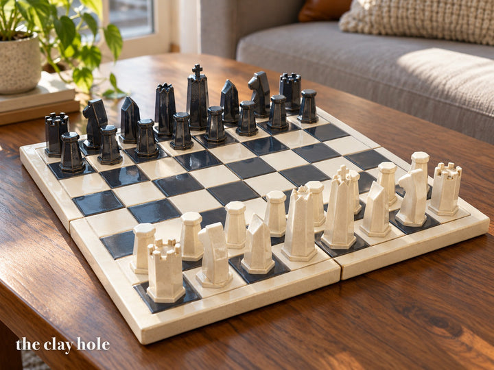 A stoneware chess set with six-sided pieces on a cream and charcoal board, made from The Clay Hole paper template
