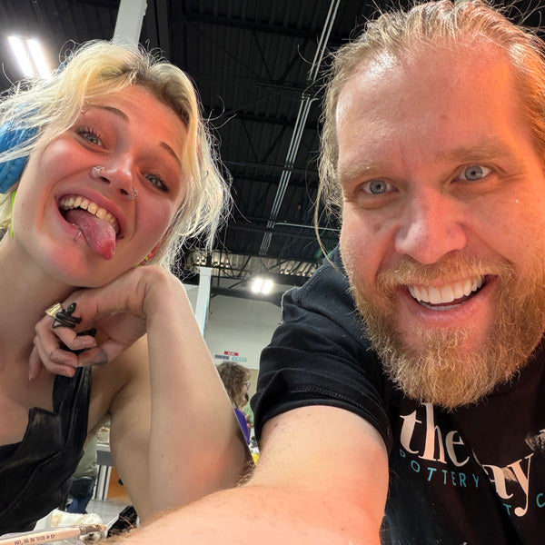 Two people laughing together in the middle of a Clay Hole class