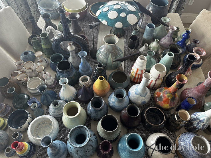 Colorful glazed pottery vases crowded together, photographed from above
