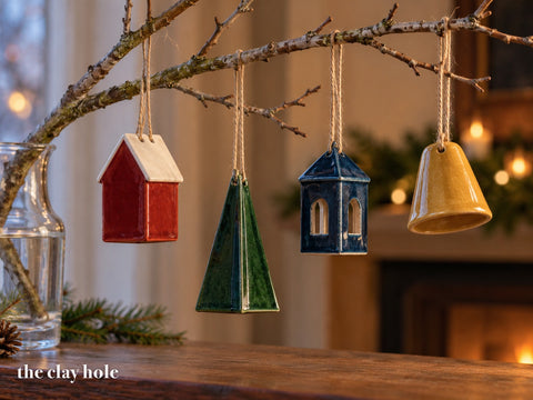 A Folded Ornaments made from The Clay Hole paper template 30: a house, a tree, a lantern and a bell, each folded from one thin slab