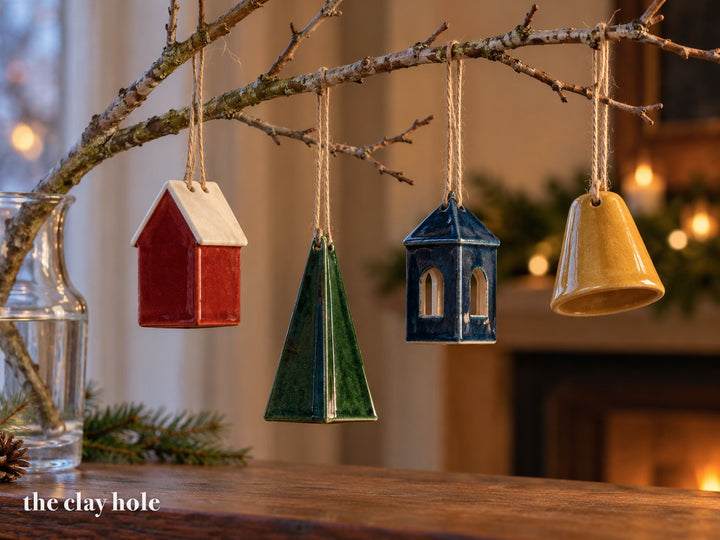A Folded Ornaments made from The Clay Hole paper template 30: a house, a tree, a lantern and a bell, each folded from one thin slab