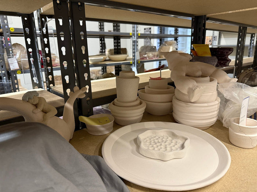 A member pottery shelf packed edge to edge with unfired work