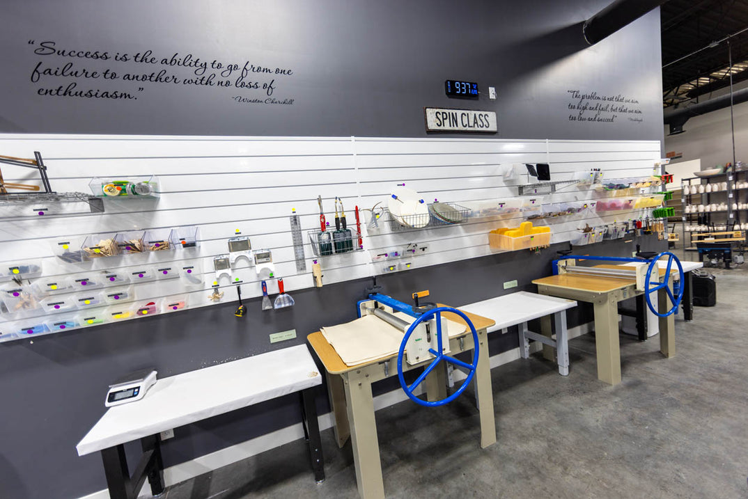 A slab roller and hand-building equipment set up along a studio wall.