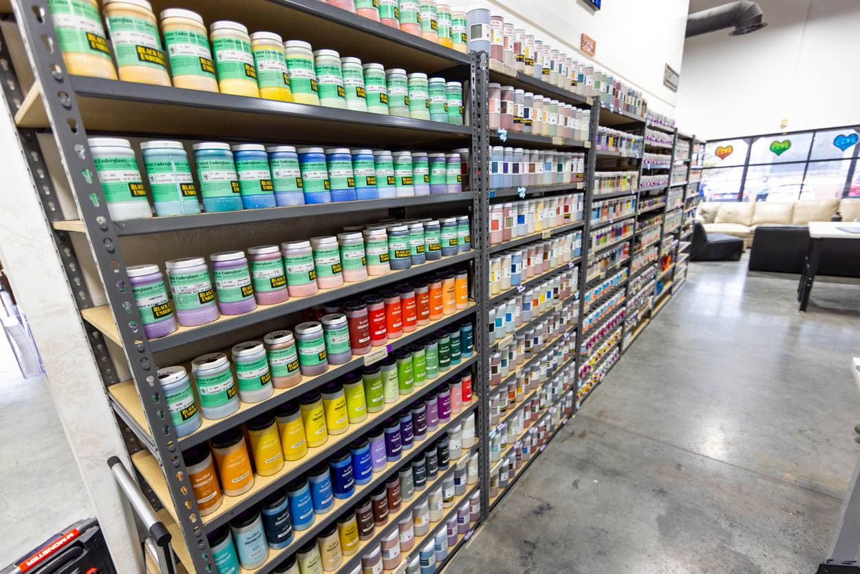 Shelves of hundreds of glaze bottles at The Clay Hole