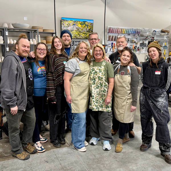 A large group of Clay Hole members standing together in aprons