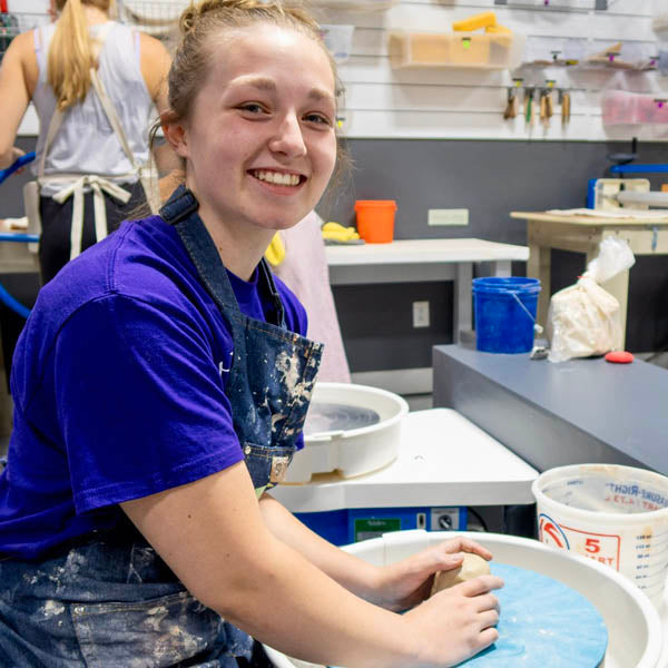 A Clay Hole member at the pottery wheel with both hands in wet clay