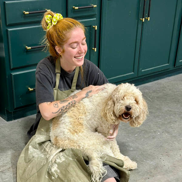 Mud draped happily across a Clay Hole member&rsquo;s lap on the studio floor in front of the dark green cabinets