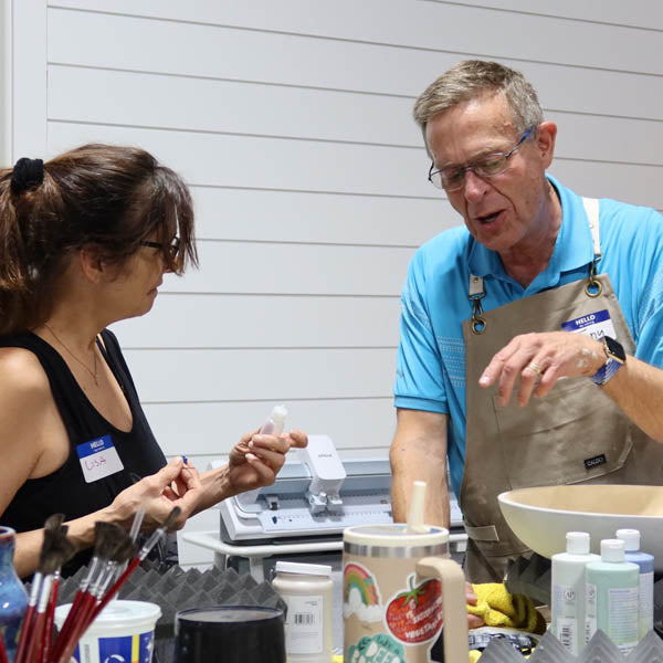 Two Clay Hole members of different generations working on clay together