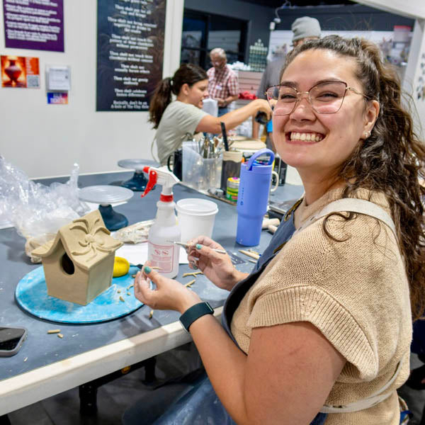 Clay Hole members laughing together while working at a studio table