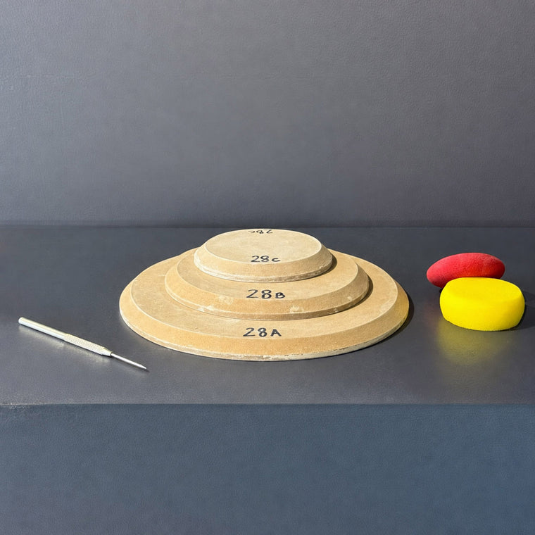 High-density fiberboard mold 28A: a flat round disc with a softened edge, the largest of a 3-piece nesting set shown stacked largest to smallest on the gray shelf, hand-labeled 28A.