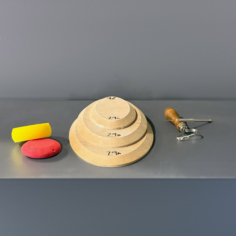 High-density fiberboard mold 29A: a flat oval disc, the largest of a 3-piece nesting set shown stacked largest to smallest on the gray shelf, hand-labeled 29A.