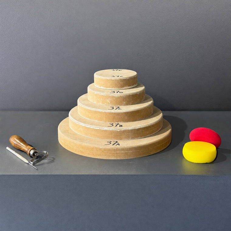 High-density fiberboard mold 37A: a thick round disc with a chamfered edge, the largest of a 5-piece nesting set shown stacked largest to smallest on the gray shelf, hand-labeled 37A.