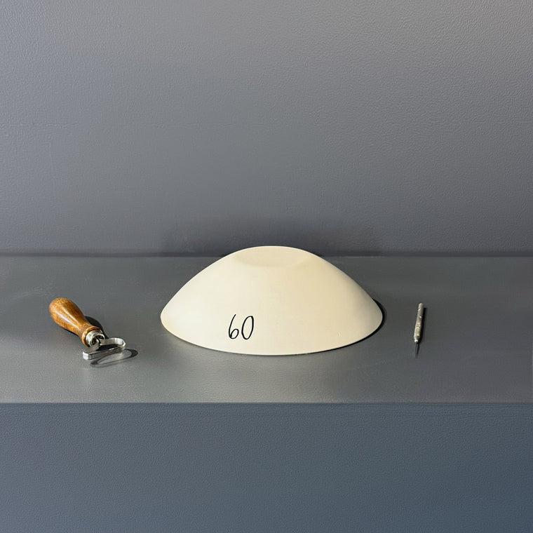 White pottery plaster hump mold number 60: a pointed oval leaf-shaped dome, tapering to points at both ends.