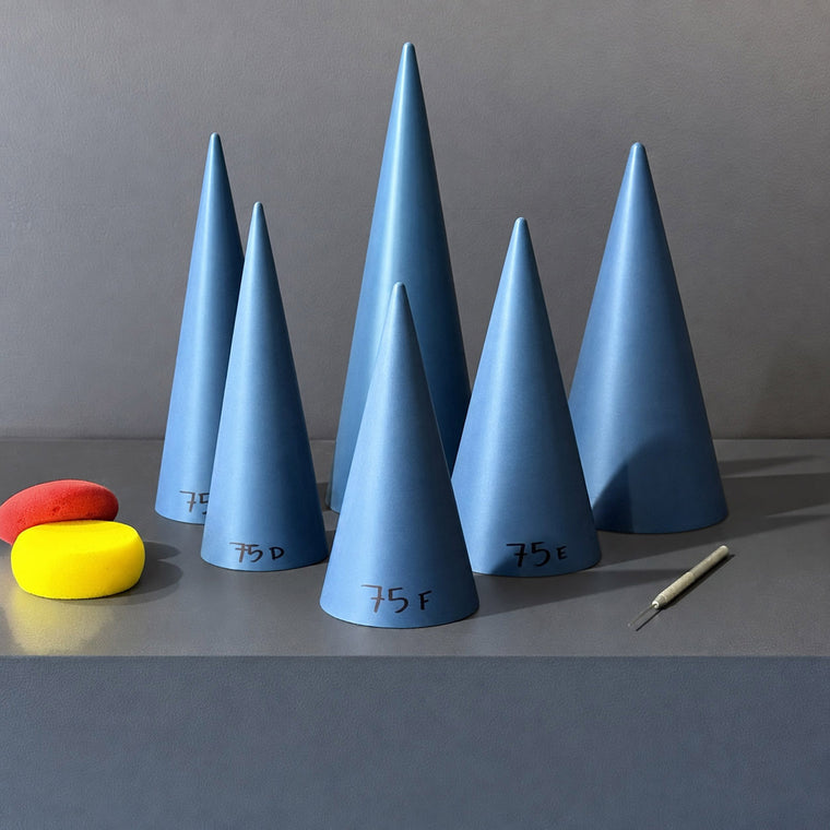 Galvanised metal cone mold 75A: a smooth conical form, standing point-up on the gray shelf among a group of six graduated cones.