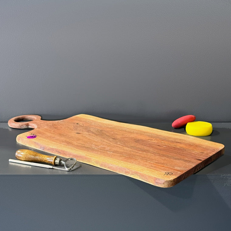 Wooden serving board used as mold number 78: a long rectangular board, measuring 25.88 in wide, 9.9 in deep and 0.5 in tall with a rounded ring handle at one end, lying on the gray shelf with a pink sticker and the number 78.