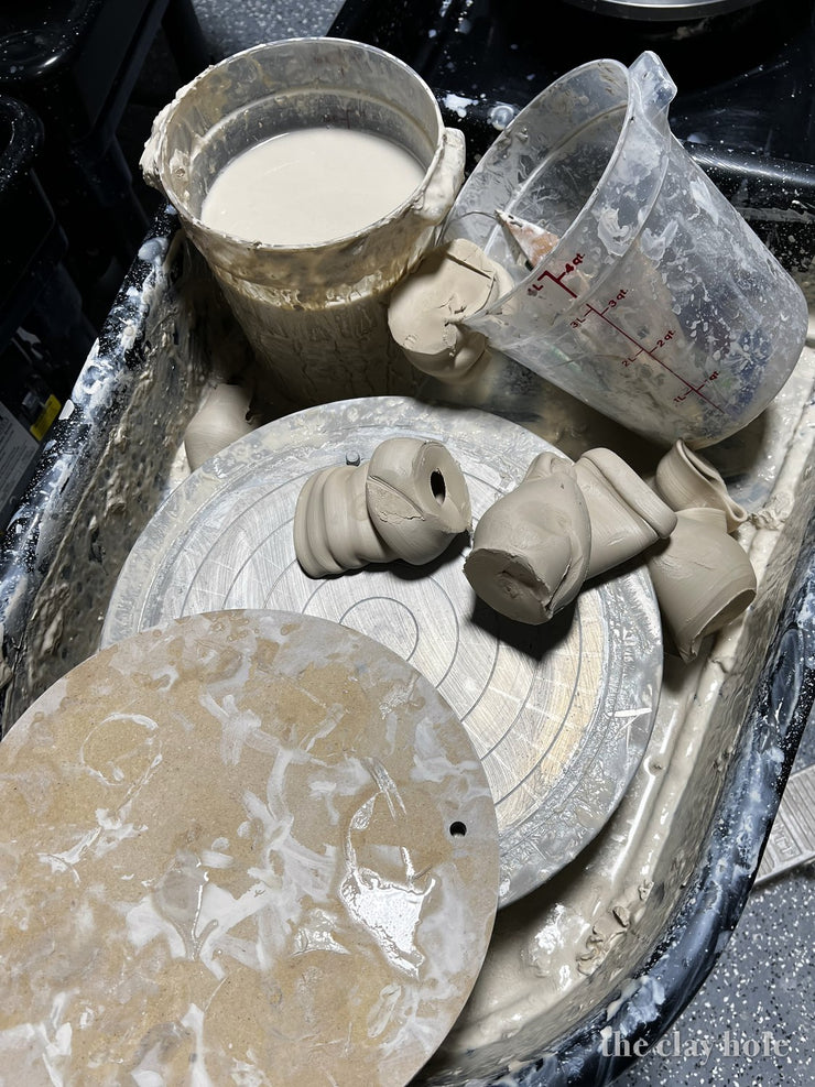 Pottery wheel splash pan filled with slip, water and trimmed clay scraps